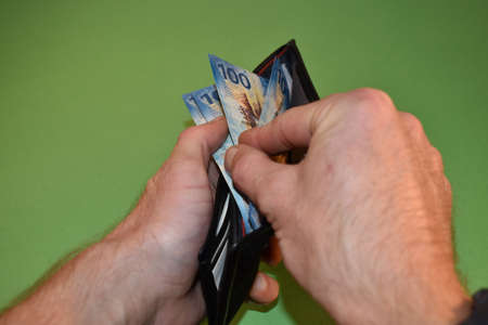 Taking off some one hundred swiss franc bills from a walletの写真素材
