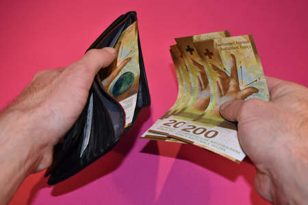 Vaduz, Liechtenstein, November 22, 2021 Taking off some two hundred swiss franc bills from a walletの写真素材