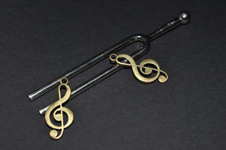Vaduz, Liechtenstein, November 19, 2021 Tuning fork with two clefs on a black backgroundの写真素材