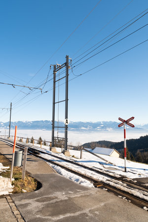 Gais, Appenzell, Switzerland, January 26, 2022 Railroad crossing in an alpine scenery on a sunny dayの写真素材