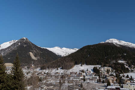Davos, Switzerland, March 23, 2022 View over the city and the fascinating snow covered alps on a clear blue sky dayのeditorial素材