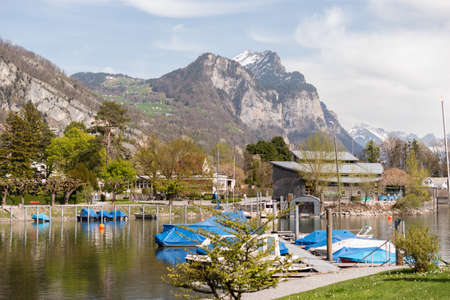 Weesen, Switzerland, April 13, 2022 Tiny boats are drifting at a little harbor at the lake Walensee in spring timeのeditorial素材