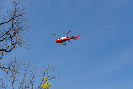 Chur, Switzerland, April 11, 2022 Helicopter is doing some cargo transportation work overhead the...