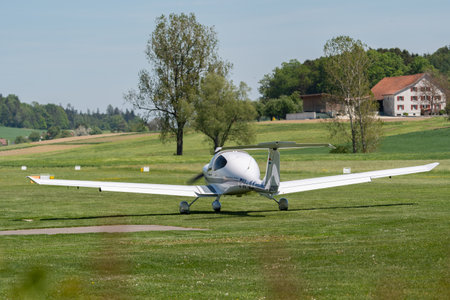 Lommis, Switzerland, May 11, 2022 Diamond DA40D propeller plane is taxiing on the grass on a small...