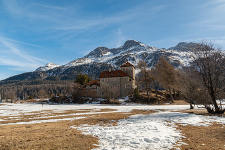 Silvaplana, Switzerland, February 21, 2023 Historic old castle Crap da Sass at the lake of Silvaplana surrounded by an incredible winter panorama on a sunny dayのeditorial素材