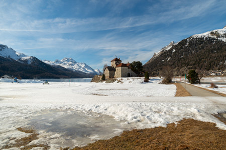 Silvaplana, Switzerland, February 21, 2023 Historic old castle Crap da Sass at the lake of Silvaplana surrounded by an incredible winter panorama on a sunny dayのeditorial素材