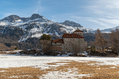 Silvaplana, Switzerland, February 21, 2023 Historic old castle Crap da Sass at the lake of Silvaplana surrounded by an incredible winter panorama on a sunny dayのeditorial素材