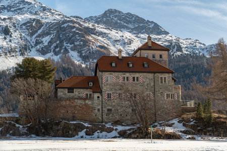 Silvaplana, Switzerland, February 21, 2023 Historic old castle Crap da Sass at the lake of Silvaplana surrounded by an incredible winter panorama on a sunny dayのeditorial素材
