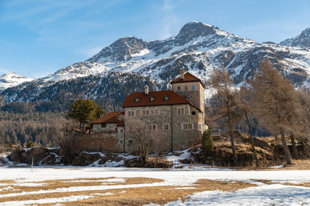 Silvaplana, Switzerland, February 21, 2023 Historic old castle Crap da Sass at the lake of Silvaplana surrounded by an incredible winter panorama on a sunny dayのeditorial素材