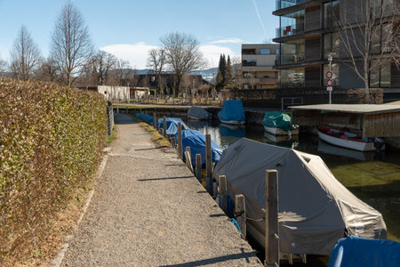 Unteraegeri, Switzerland, February 20, 2023 Small boats are covered and stored in a small canal at the lake Aegeriseeのeditorial素材