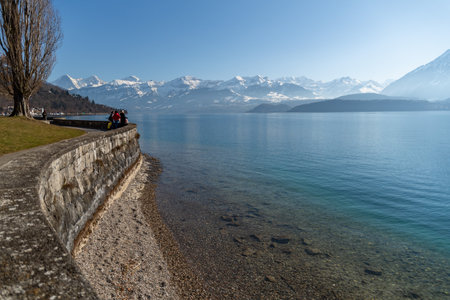 Oberhofen, Canton Bern, Switzerland, February 12, 2023 Lovely view over the lake of Thun and an alpine scenery on a sunny dayのeditorial素材
