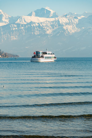 Thun, Switzerland, February 12, 2023 Little boat with passengers on a cruise trip over the lake of...