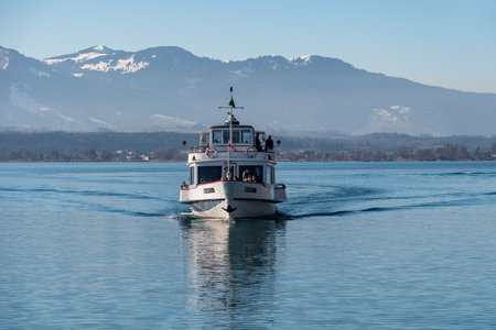 Oberhofen, Canton Bern, Switzerland, February 12, 2023 Small boat is taking tourists to a trip over the lake of Thun on a sunny dayのeditorial素材