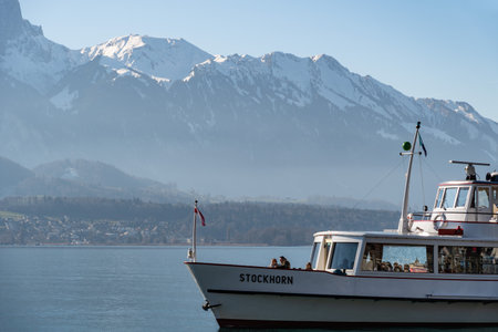 Oberhofen, Canton Bern, Switzerland, February 12, 2023 Small boat is taking tourists to a trip over the lake of Thun on a sunny dayのeditorial素材