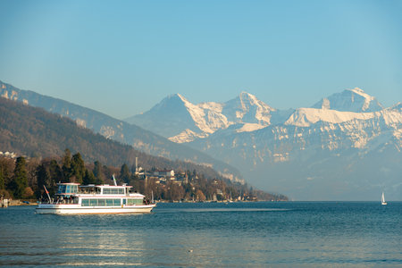 Thun, Switzerland, February 12, 2023 Little boat with passengers on a cruise trip over the lake of Thunのeditorial素材
