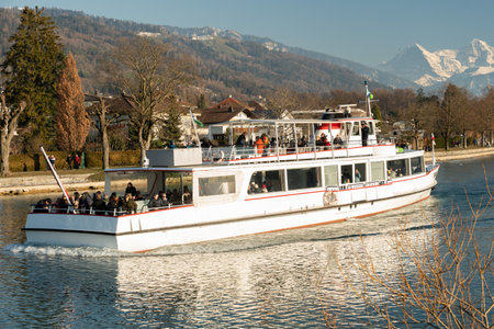 Thun, Switzerland, February 12, 2023 Little boat with passengers on a cruise trip over the lake of Thunのeditorial素材