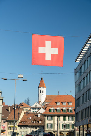 Thun, Switzerland, February 13, 2023 Swiss flag is hanging over a main street in the city centerのeditorial素材