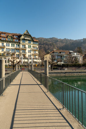Thun, Switzerland, February 13, 2023 Pedestrian bridge over the Aare river at the waterfront in the city centerのeditorial素材