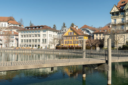 Thun, Switzerland, February 13, 2023 Pedestrian bridge over the Aare river at the waterfront in the city centerのeditorial素材