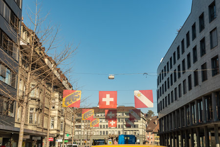 Thun, Switzerland, February 13, 2023 Swiss flag is hanging over a main street in the city centerのeditorial素材