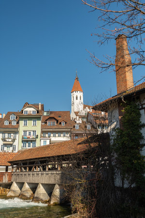 Thun, Switzerland, February 13, 2023 Historic old wooden bridge across the Aare river at the water promenade in the city centerのeditorial素材