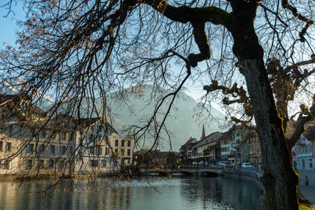 Interlaken, Switzerland, February 10, 2023 Water promenade along the Aare river in the city center with the majestic alps in the backgroundの写真素材