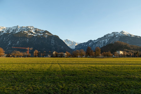 Interlaken, Switzerland, February 10, 2023 View over a green park and a fascinating mountain panorama in the city centerのeditorial素材