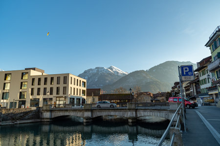 Interlaken, Switzerland, February 10, 2023 Water promenade along the Aare river in the city center with the majestic alps in the backgroundのeditorial素材