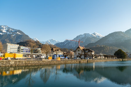 Interlaken, Switzerland, February 10, 2023 Water promenade along the Aare river in the city center with the majestic alps in the backgroundのeditorial素材