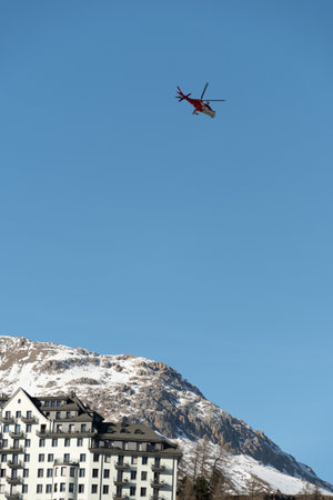 Saint Moritz, Switzerland, February 21, 2023 REGA air ambulance helicopter in the blue skyのeditorial素材