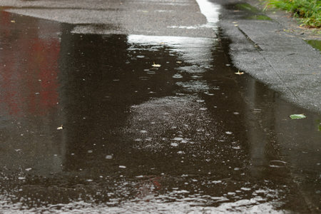 Salez, Switzerland, August 28, 2023 Rain falls into a puddle on a streetの写真素材