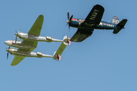 Mollis, Switzerland, August 18, 2023 Lockheed P-38L Lightning and a Chance Vought F4U-4 Corsair aircraft during an air displayのeditorial素材