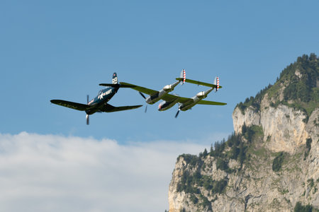 Mollis, Switzerland, August 18, 2023 Lockheed P-38L Lightning and a Chance Vought F4U-4 Corsair aircraft during an air displayのeditorial素材