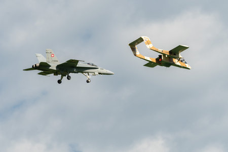 Mollis, Switzerland, August 18, 2023 North american OV-10B Bronco airplane escorted with a McDonnell Douglas F/A-18 Hornet military jet during an air displayのeditorial素材