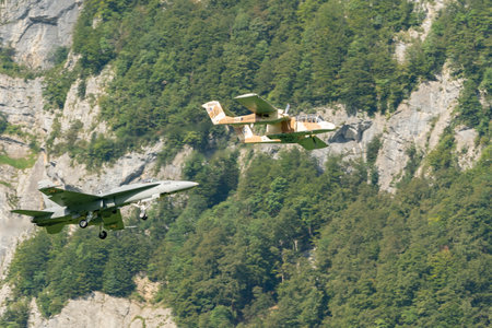 Mollis, Switzerland, August 18, 2023 North american OV-10B Bronco airplane escorted with a McDonnell Douglas F/A-18 Hornet military jet during an air displayのeditorial素材