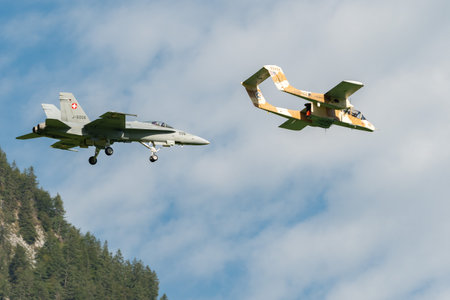 Mollis, Switzerland, August 18, 2023 North american OV-10B Bronco airplane escorted with a McDonnell Douglas F/A-18 Hornet military jet during an air displayのeditorial素材