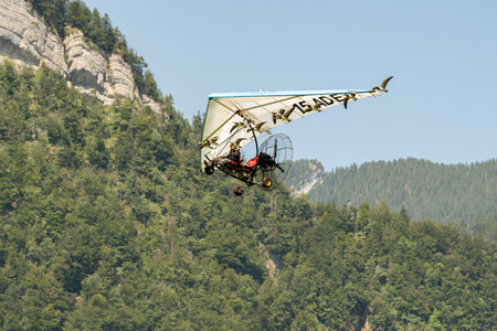 Mollis, Switzerland, August 18, 2023 Ultralight airplane is escorted with birds during an air displayのeditorial素材
