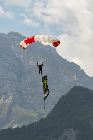 Mollis, Switzerland, August 18, 2023 Parachuters with a waving flag during an air showのeditorial素材