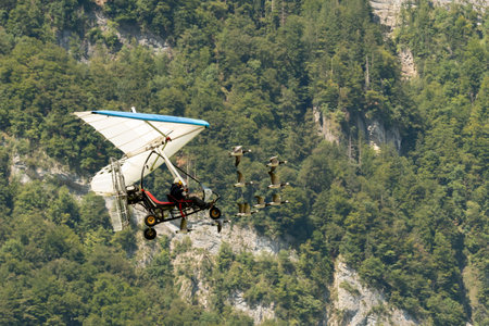 Mollis, Switzerland, August 18, 2023 Ultralight airplane is escorted with birds during an air displayのeditorial素材