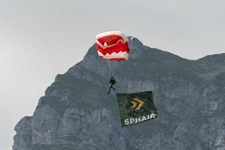 Mollis, Switzerland, August 18, 2023 Parachuters with a waving flag during an air showのeditorial素材