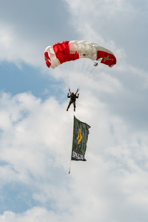Mollis, Switzerland, August 18, 2023 Parachuters with a waving flag during an air showのeditorial素材