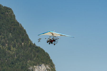 Mollis, Switzerland, August 18, 2023 Ultralight airplane is escorted with birds during an air displayのeditorial素材