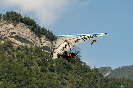 Mollis, Switzerland, August 18, 2023 Ultralight airplane is escorted with birds during an air displayのeditorial素材