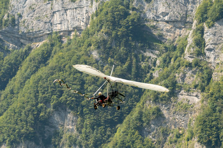 Mollis, Switzerland, August 18, 2023 Ultralight airplane is escorted with birds during an air displayのeditorial素材