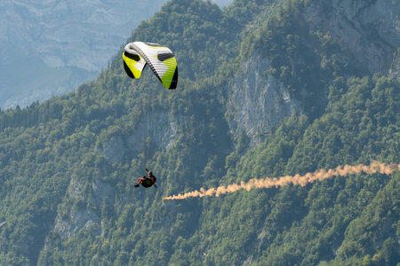 Mollis, Switzerland, August 18, 2023 Parachute performance in an alpine scenery during an air displayのeditorial素材