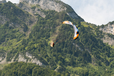 Mollis, Switzerland, August 18, 2023 Parachute performance in an alpine scenery during an air displayのeditorial素材