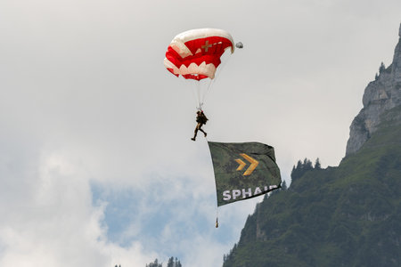 Mollis, Switzerland, August 18, 2023 Parachuters with a waving flag during an air showのeditorial素材
