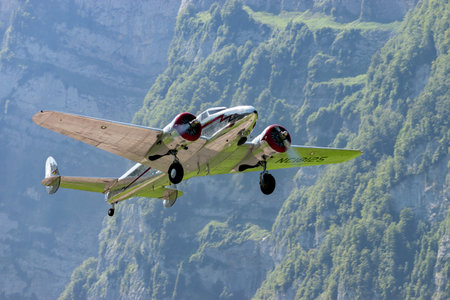 Mollis, Switzerland, August 18, 2023 NC-18125 Lockheed Model 12 Electra Junior historic aircraft is taking off from runway 01のeditorial素材