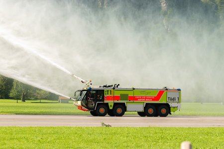 Mollis, Switzerland, August 18, 2023 Firefighter truck presentation with splashing water during an air showのeditorial素材