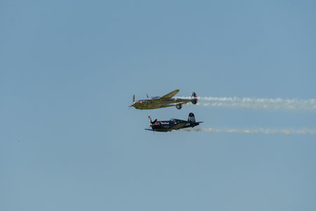 Mollis, Switzerland, August 18, 2023 Lockheed P-38L Lightning and a Chance Vought F4U-4 Corsair historic aircraft in formation flight during an air displayのeditorial素材